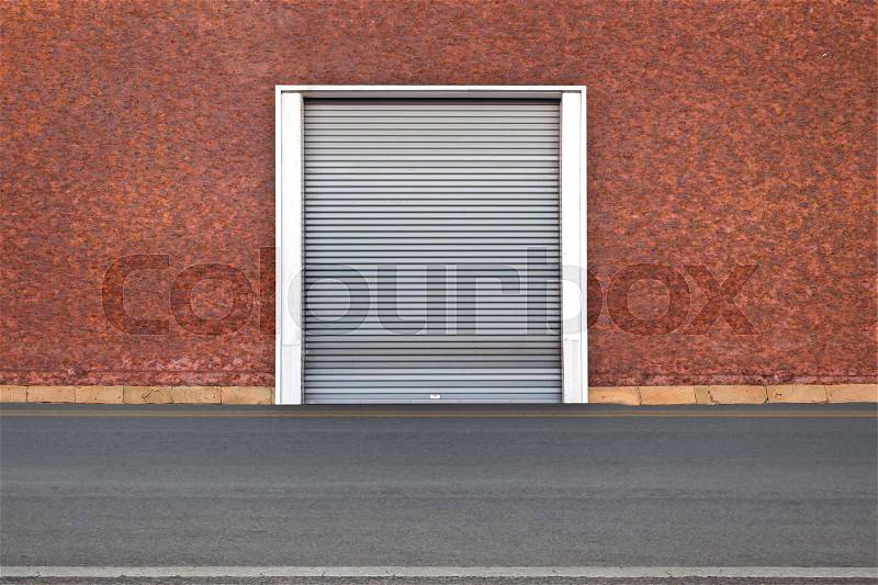 Roller shutter door and concrete floor outside factory building for industrial background, stock photo