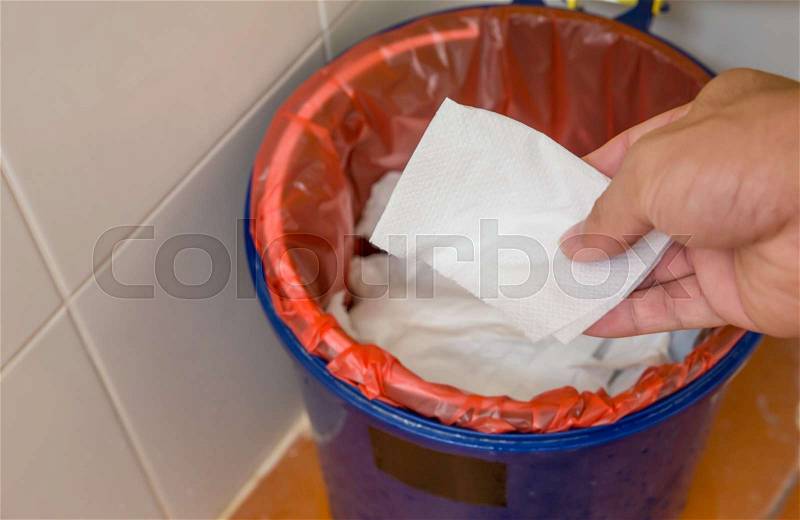 Woman\'s Hand throwing scarp of Paper into recycling bin, hand holding piece of garbage in trash can, stock photo
