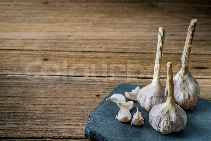 Image of Garlic on black stone plate, stock photo