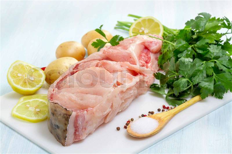 Raw Catfish with herbs and spices on table, stock photo