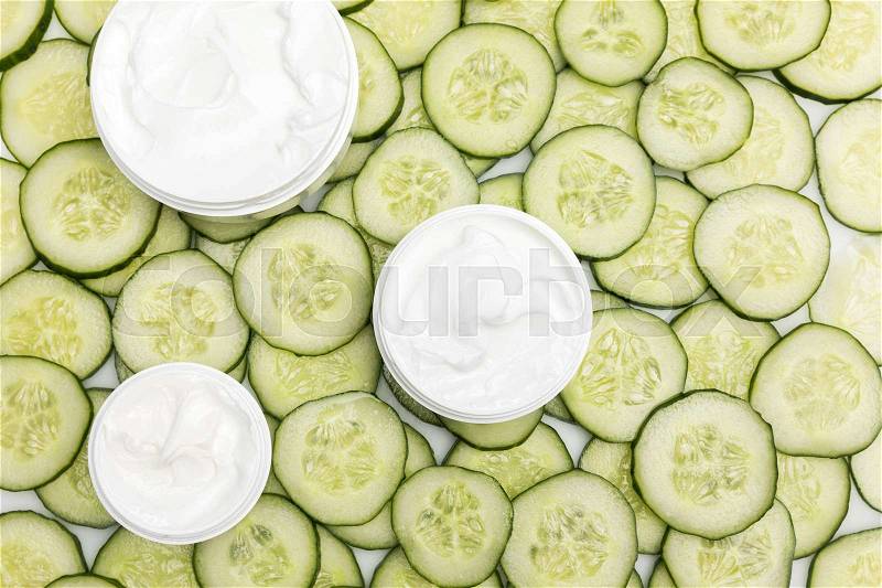 Top view of facial cream in containers and cucumber slices , stock photo