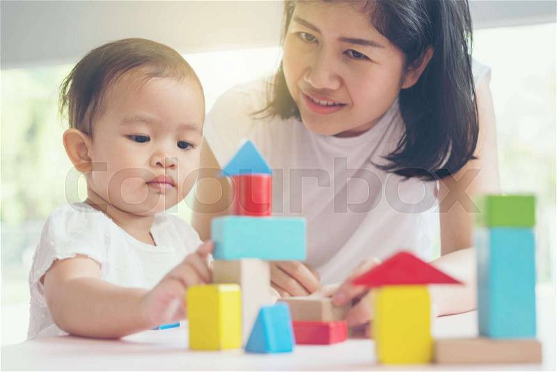 Asian mom and girl kid playing with blocks. Vintage effects and soft light, stock photo