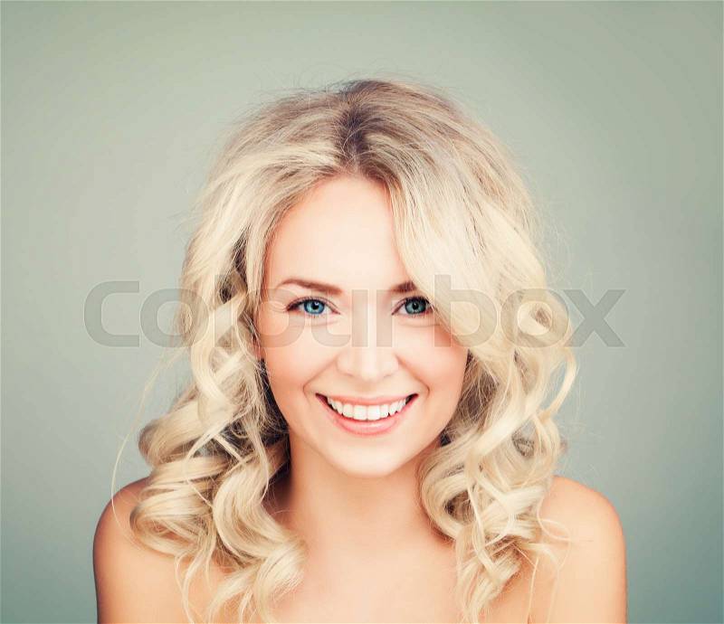 Happy Blonde Woman with Blonde Curly Hair. Smiling Fashion Model with Wavy Hairstyle, stock photo