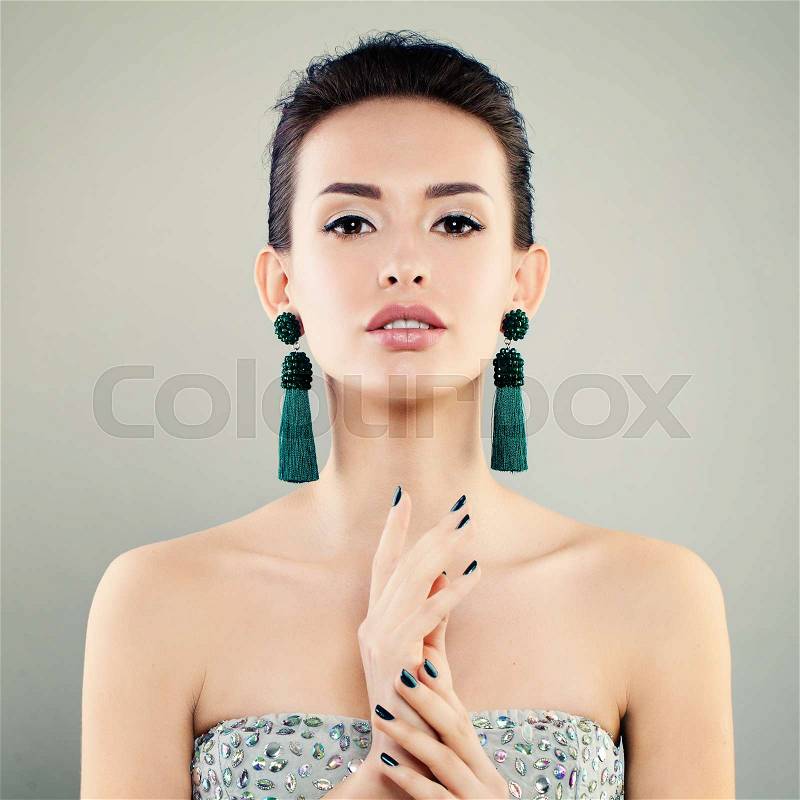 Beautiful Model Woman with Makeup, Manicure and Green Earrings. Cute Young Face, stock photo