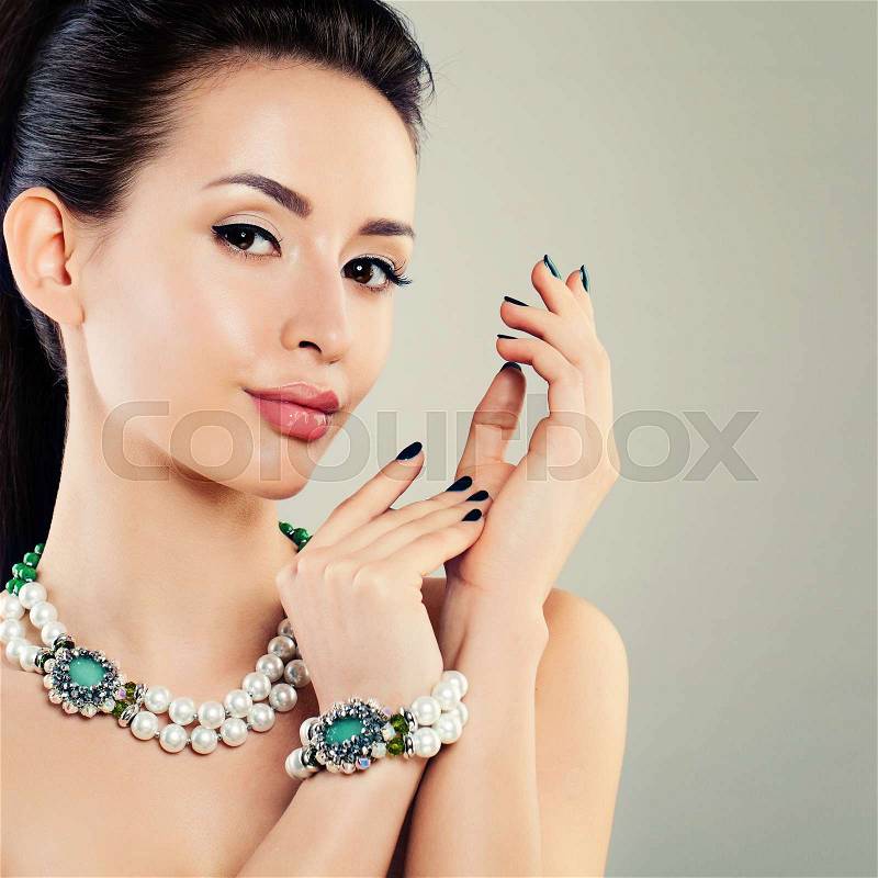 Perfect Glamorous Model Woman with Pearls Necklace and Bracelet. Jewelry Pearls and Green Crystals, stock photo