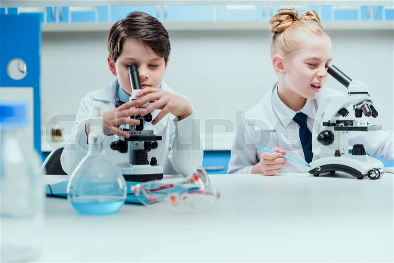 Schoolchildren with science lab equipment in chemical lab, scientists kids group concept, stock photo