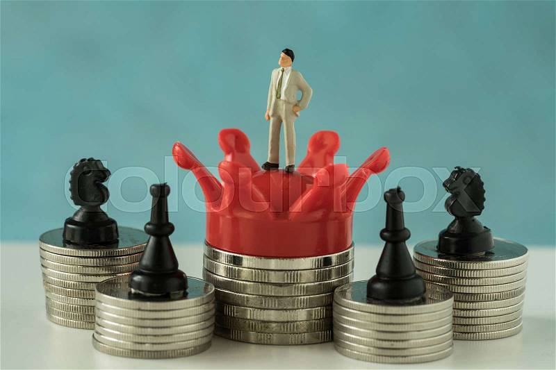 Miniature figure business man standing on red crown king with stack of coins and chess symbol as financial business growth success concept, stock photo