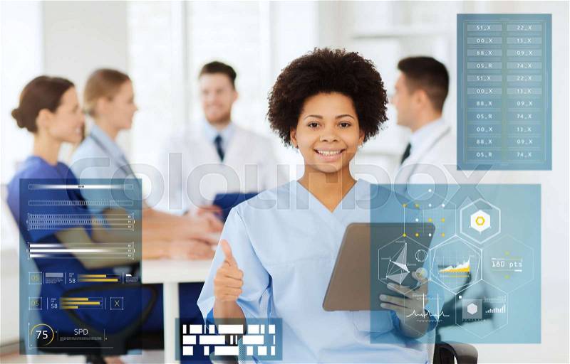 Medicine, healthcare, technology and people concept - happy african american female doctor with tablet pc computer over group of medics meeting at hospital showing thumbs up gesture, stock photo