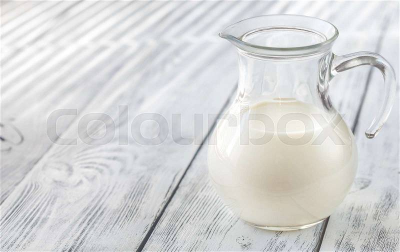 Glass pitcher of milk, stock photo