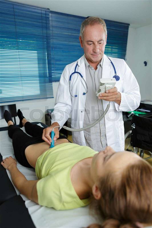 Doctor doing 3d ultrasound on belly of woman in clinic, stock photo