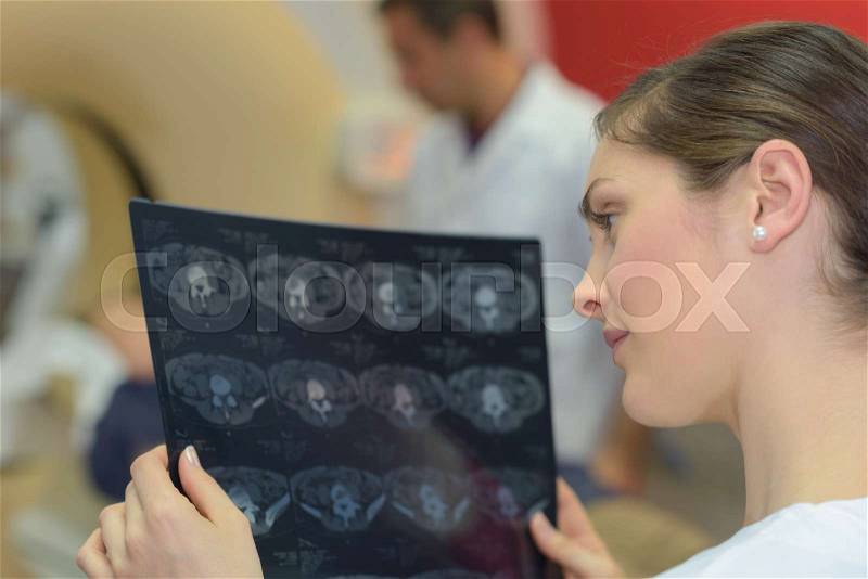 Beautiful woman doctor looking at a x ray, stock photo
