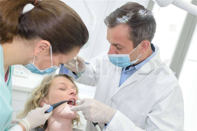 Dentists examining a patients teeth in the dentist, stock photo
