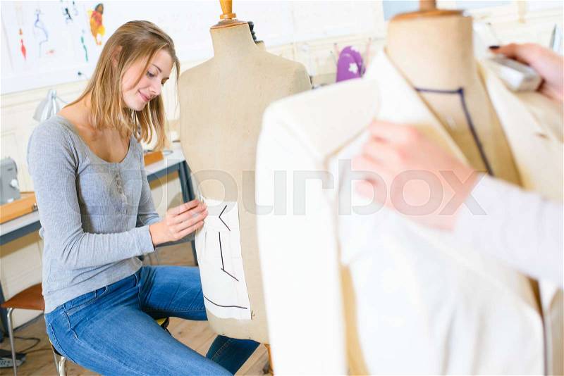 Happy female tailor with tailors dummy, stock photo