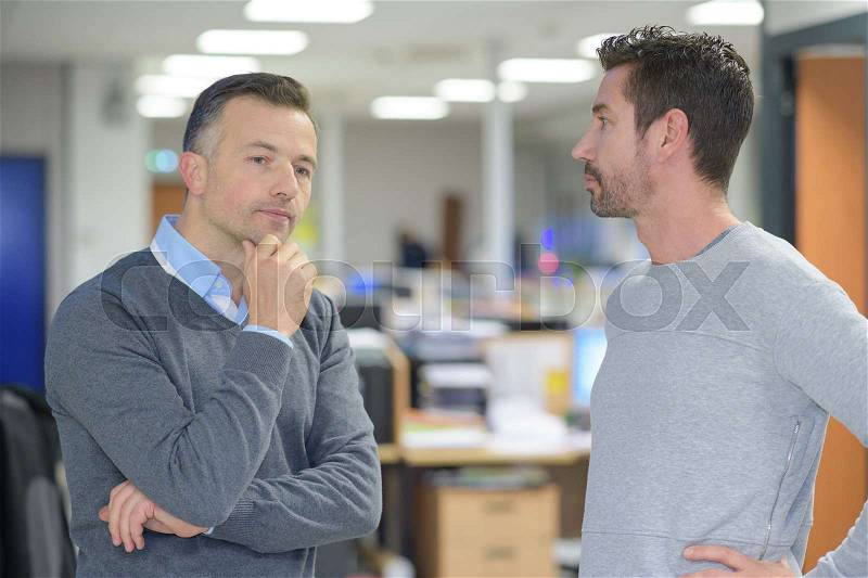Businessmen talking at creative work space, stock photo