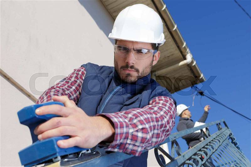 Worker operating a sky lift to do maintenance work outdoor, stock photo
