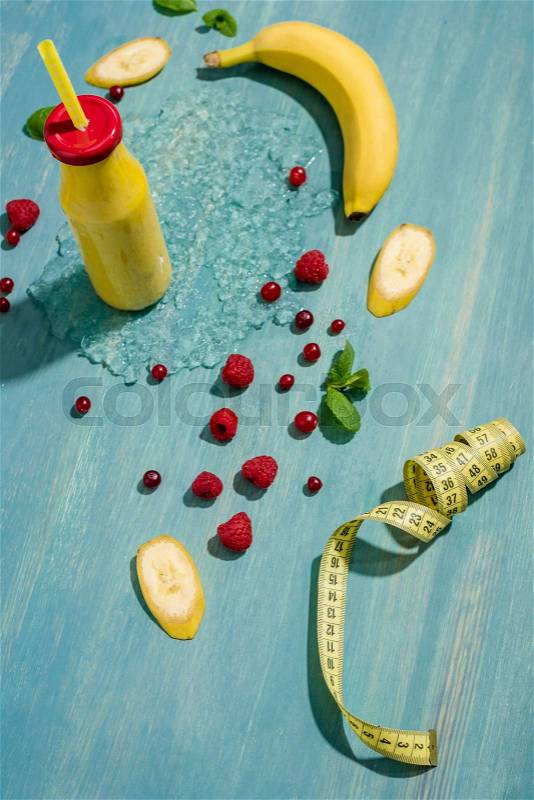 Top view of bottle with fresh banana smoothie and berries with mint leaves, smoothie fruits, stock photo