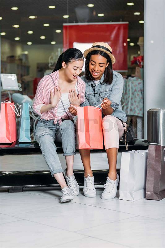 Stylish women friends shopping together at shopping mall, stock photo