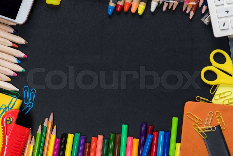 Top view of frame from colorful school and office supplies on black, stock photo