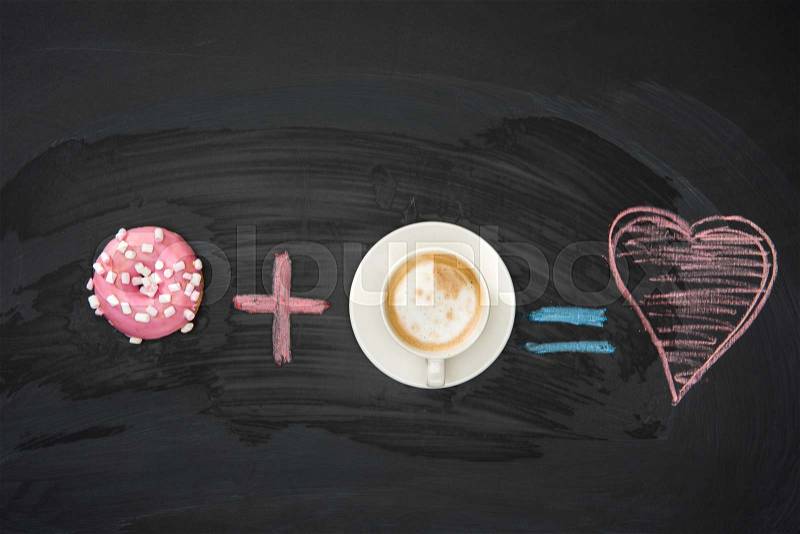 Food composition of donut with pink glaze and cup of coffee on black surface. donuts and coffee concept, stock photo
