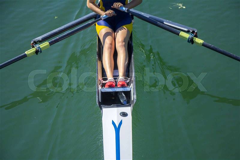 A young girl rowing in boat on water , stock photo