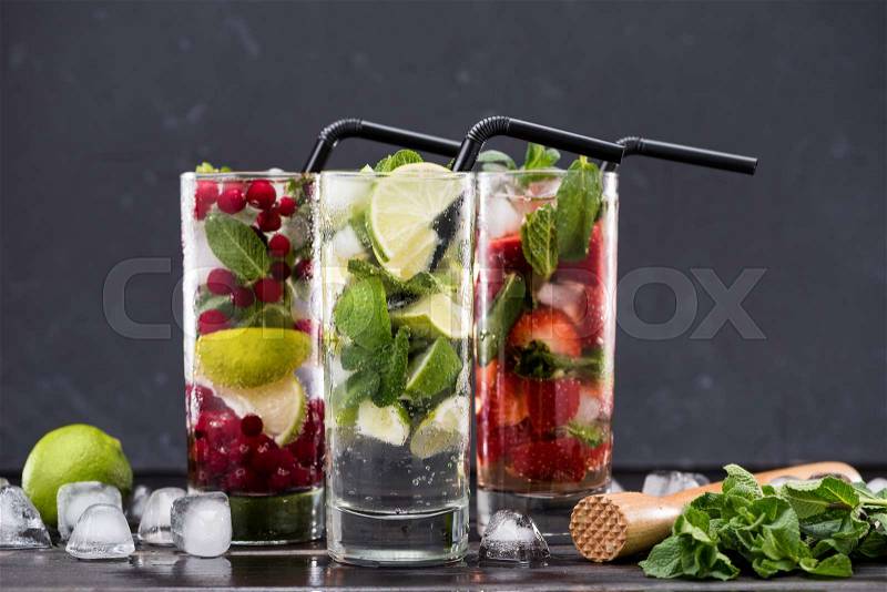 Different fresh lemonades in glasses with ice cubes, cocktail glasses concept, stock photo