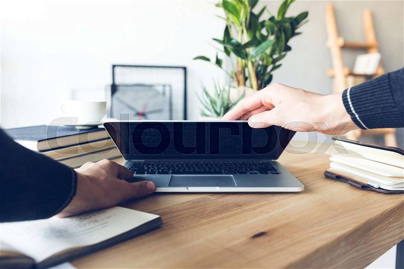 Human hands holding laptop at workplace in home office, stock photo