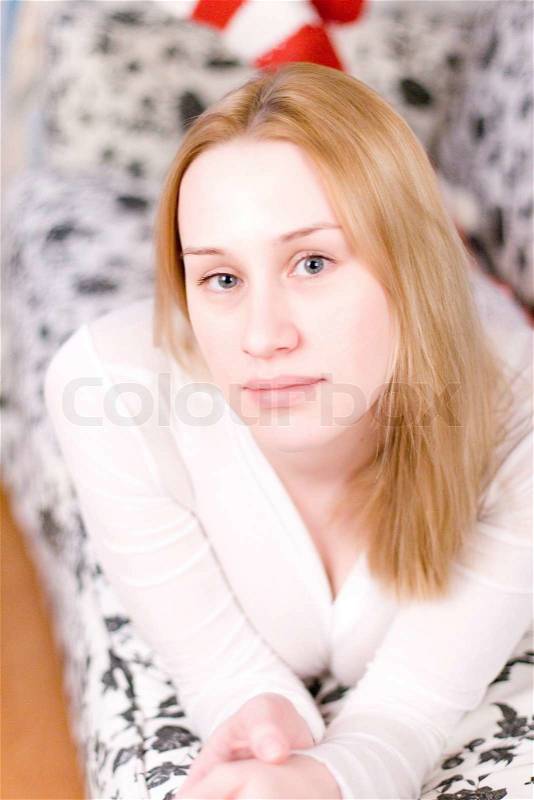 Portrait of blond woman laying on the sofa, stock photo