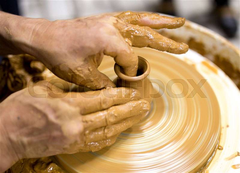 The master makes by hands the product of dishes from clay, stock photo