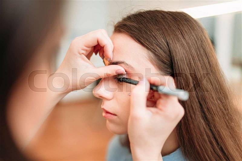 Make up artist work with woman eyes, beauty studio on background. Cosmetic salon, stock photo