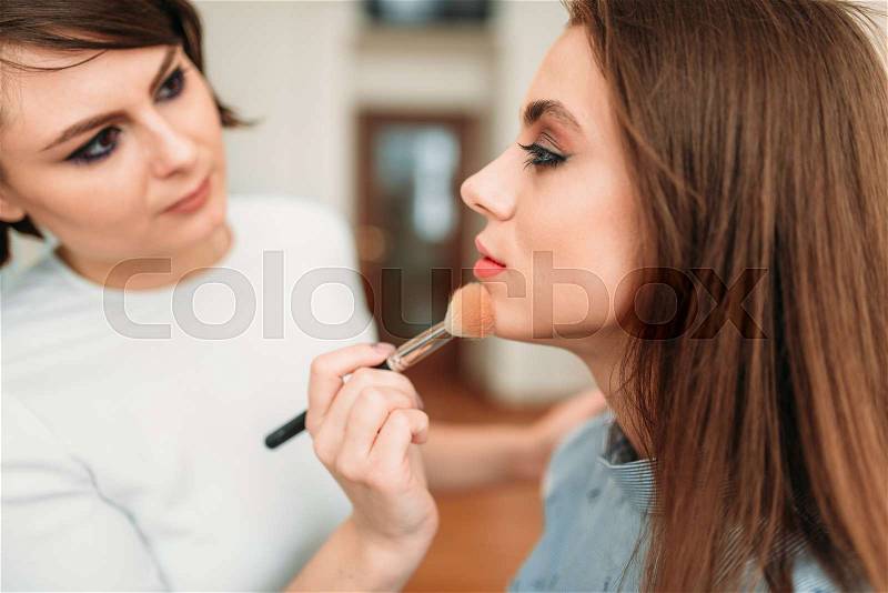 Female make up artist work with beautiful woman face, beauty studio on background. Cosmetic salon, stock photo
