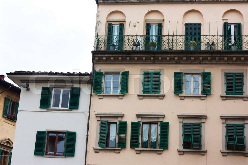 Old Italian house with green shutters and balconies and medieval architecture, stock photo