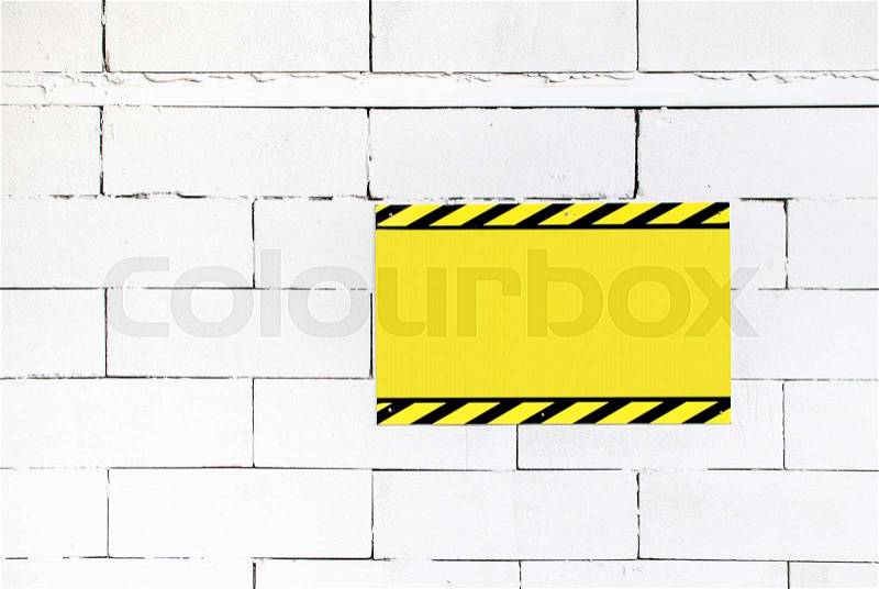 Cement block wall with blank warning poster,template to fill your text, stock photo