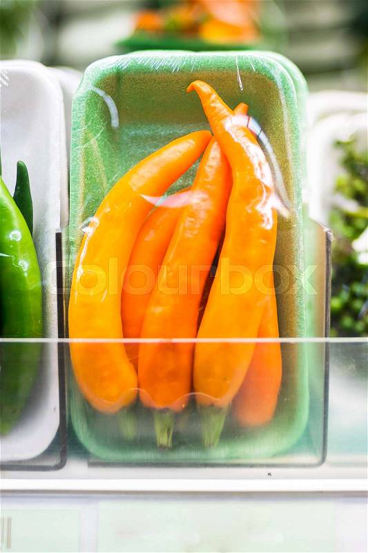 Chilli in plastic wrap at supermarket, stock photo