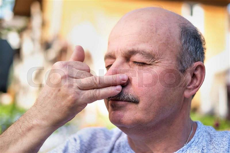 Handsome mature man with mustache breathing yoga pranayama on summer sunny day outside, stock photo