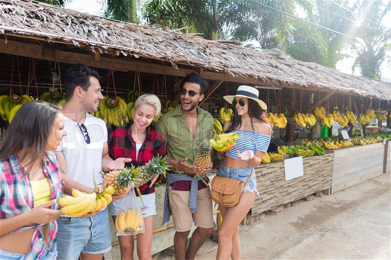 People Group Buying Bananas And Pineapples On Street Traditional Market, Young Man And Woman Travelers Choosing Fresh Fruits, stock photo
