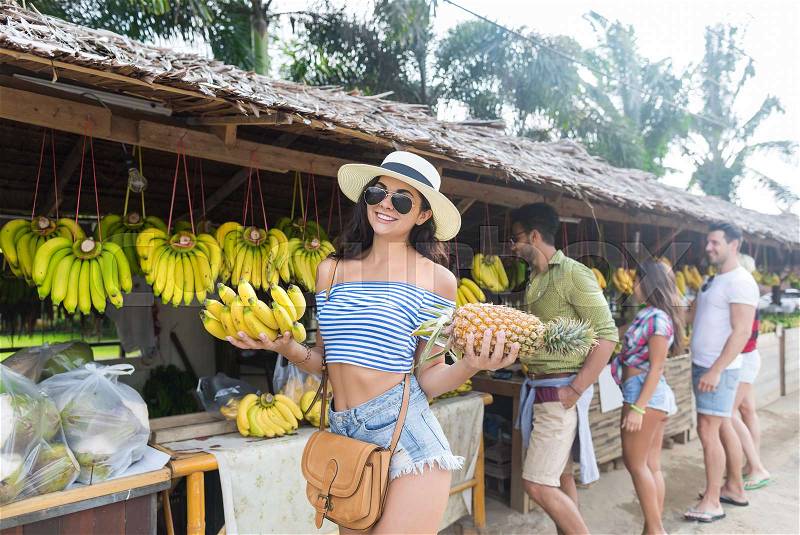 Woman Hold Bananas And Pineapple On Street Traditional Market, Young Man And Woman Travelers Choosing Fresh Fruits, stock photo