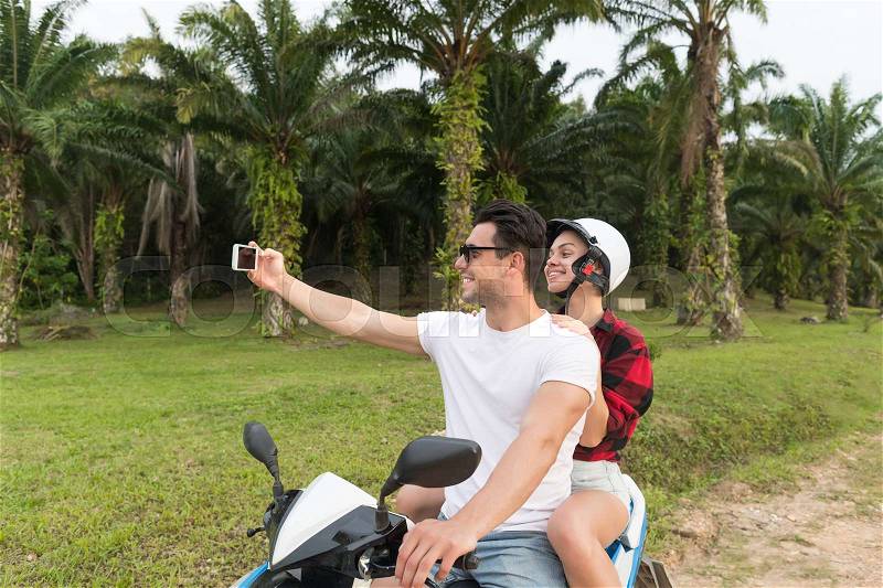 Couple Riding Motorbike, Man And Woman Taking Selfie Travel On Bike On Tropical Forest Road During Exotic Summer Holiday, stock photo