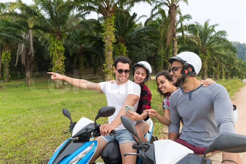 Two Couple Riding Motorbike, Young Man And Woman Using Cell Smart Phone Travel On Bike On Tropical Forest Road During Exotic Summer Holiday, stock photo