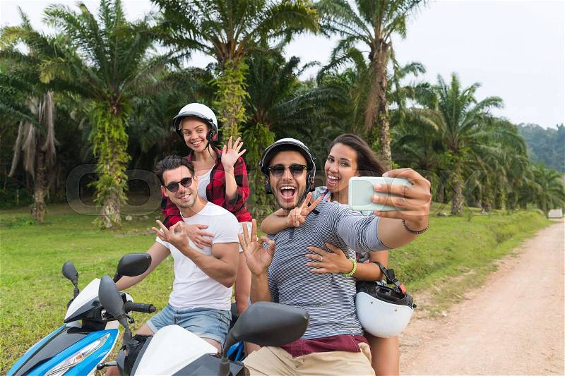 Two Couple Riding Motorbike, Man And Woman Taking Selfie Travel On Bike On Tropical Forest Road During Exotic Summer Holiday, stock photo