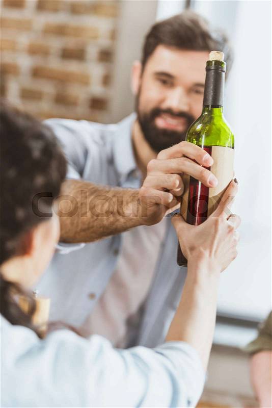 Young man with girl holding wine bottle , stock photo
