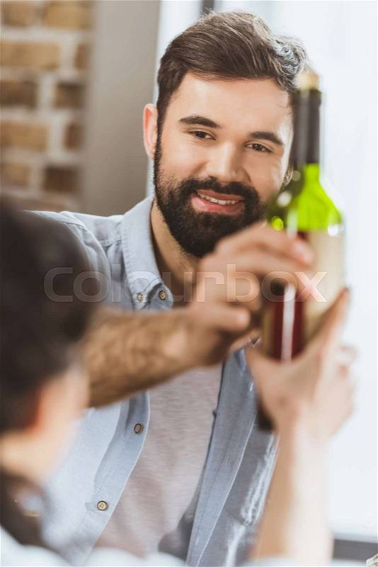 Young man with girl holding wine bottle , stock photo