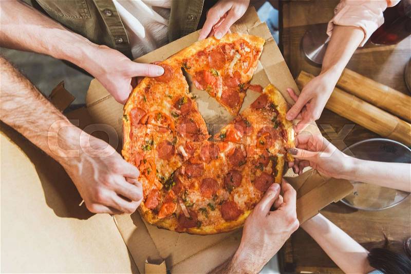 Young people eating pizza. Top view hands with pizza, stock photo