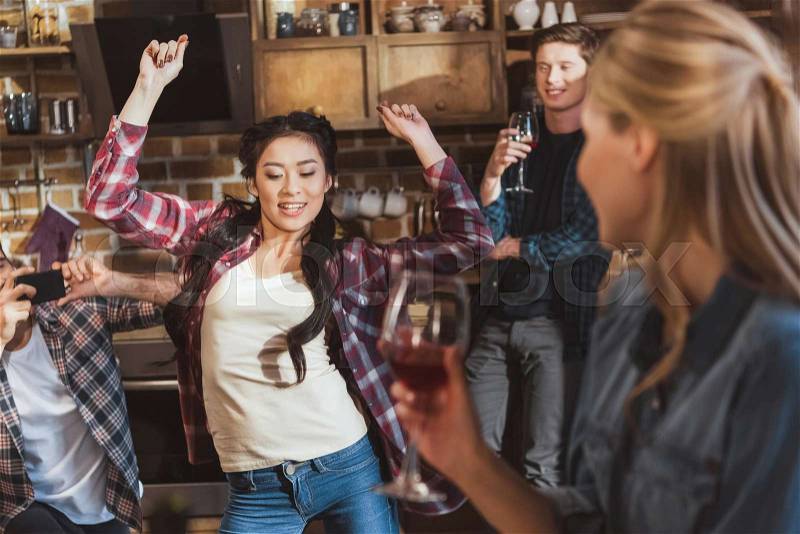 Young people partying, drinking wine and having fun at home party, stock photo