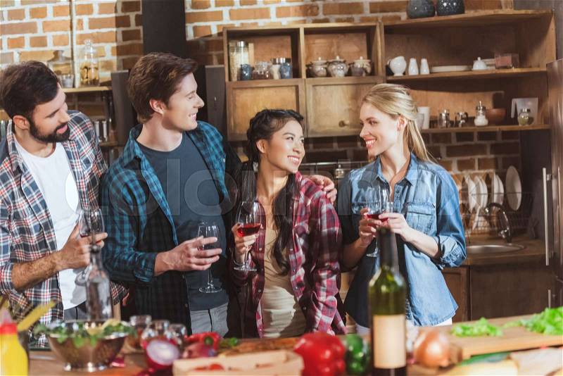 Young people partying, drinking wine and having fun at home party, stock photo