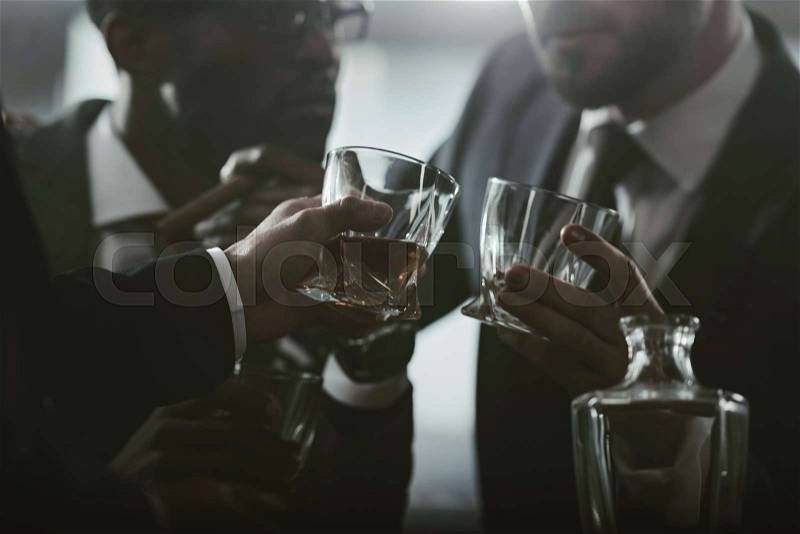 Cropped view of business team spending time and drinking whiskey, stock photo