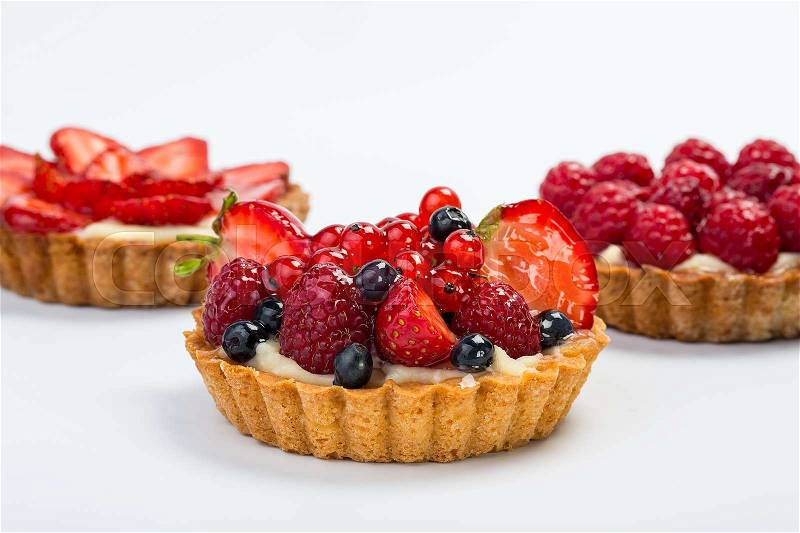 Three Fresh Fruit Tarts with berries isolated on white background. Sweet basket with berries, stock photo