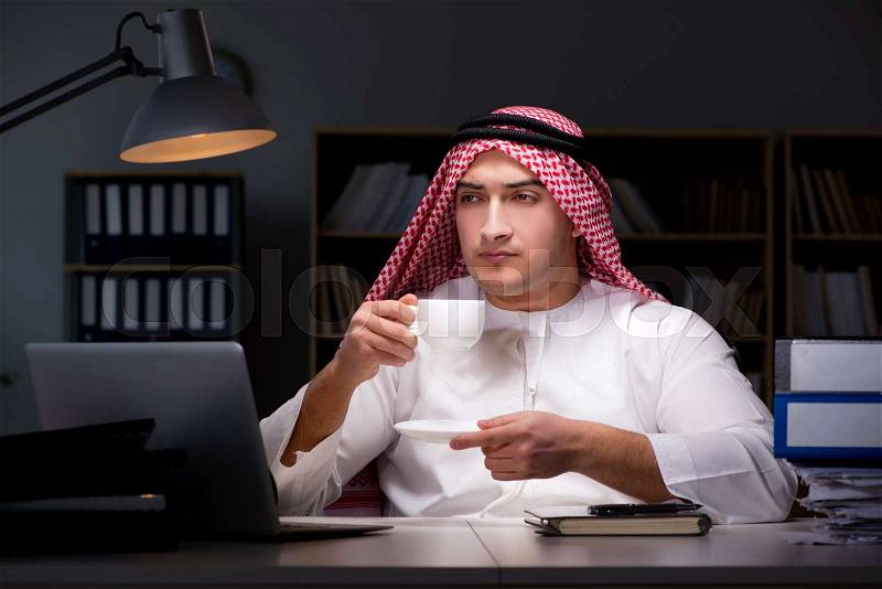 Arab businessman working late in office, stock photo