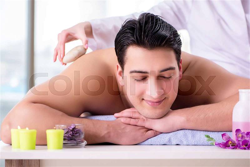 Handsome man in spa massage concept, stock photo