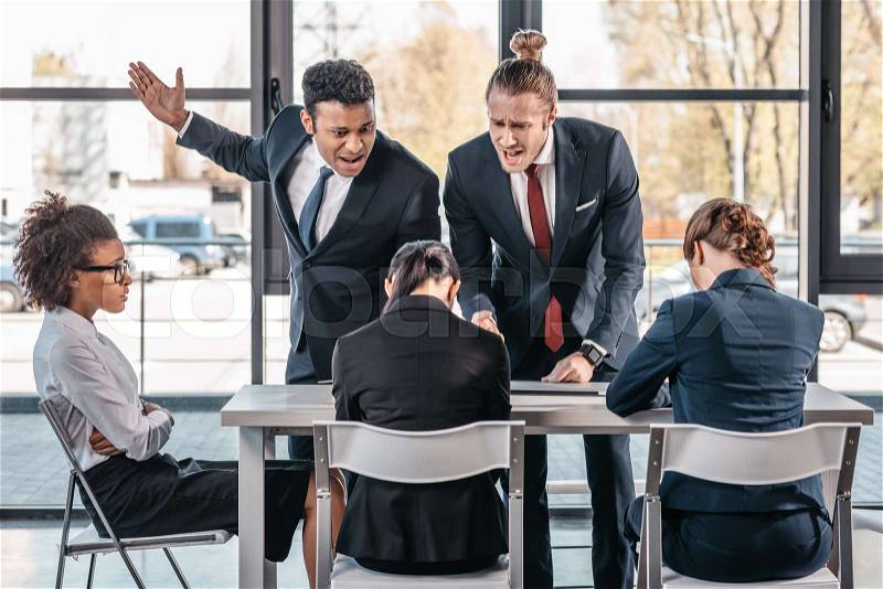 Young emotional businesspeople in formalwear arguing at meeting in office, business team meeting, stock photo