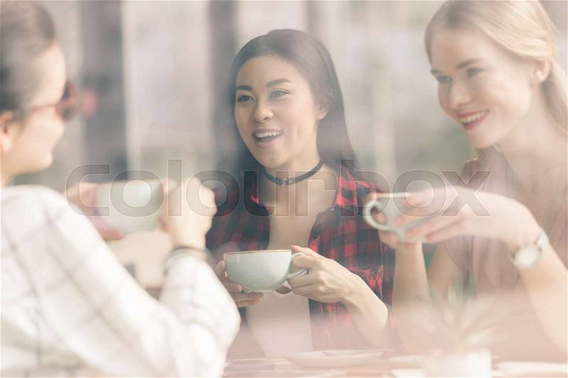 Friends spend time together on coffee break in cafe, stock photo